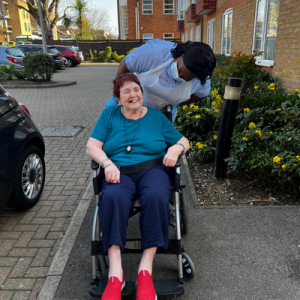 Lady in wheelchair getting pushed along the path by Comfort Care at Home nurse